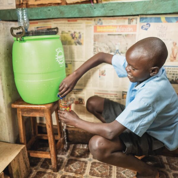 boy using new water filter in Kenya